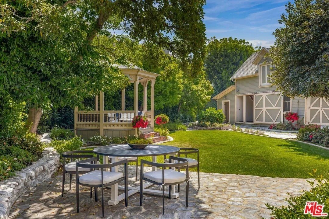 The lush backyard contains a gazebo, carriage house, and flagstone terrace.