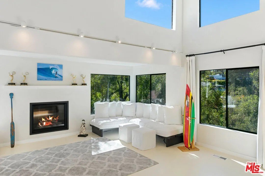 The light-filled sunken living room is highlighted by with an Emmy bedecked fireplace (awards not included).