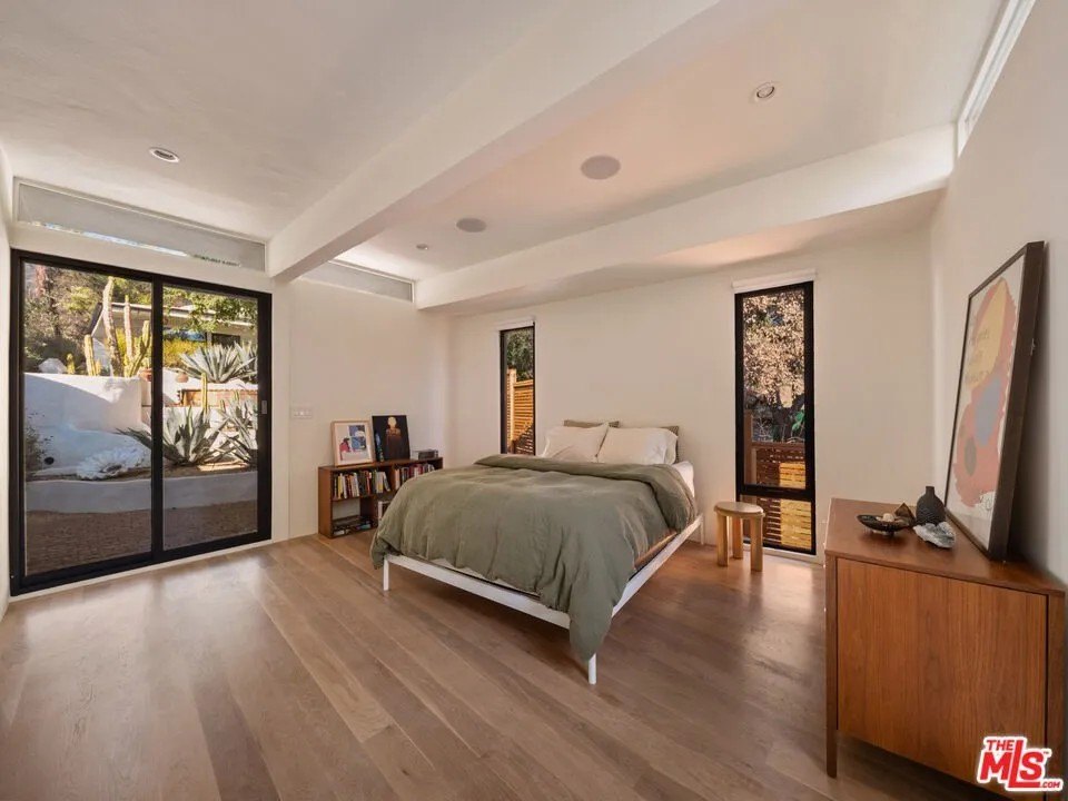 The primary suite has an expansive floor to ceiling window, a private bath and a slider that opens to a landscaped courtyard.