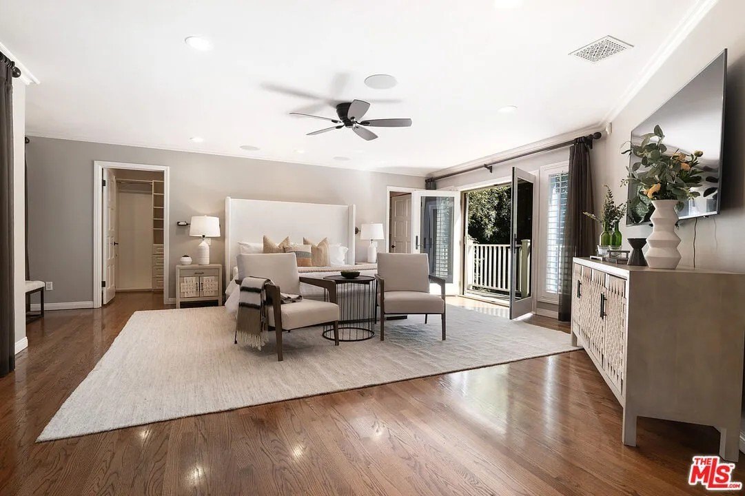 The primary suite is located upstairs, and features a sitting area with a fireplace, a walk-in closet, a luxurious bath, and still more French doors that lead to a private balcony overlooking the lush grounds.