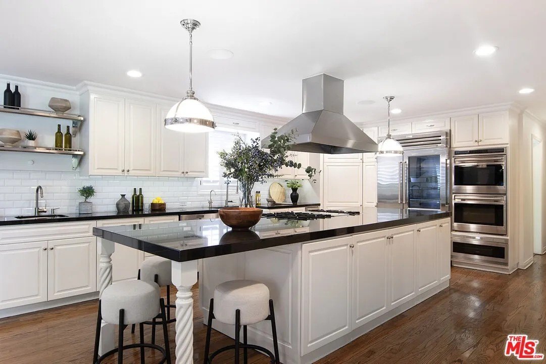 The elegant yet functional kitchen a gourmet kitchen  features a center island with prep space and a breakfast bar, plus luxury stainless steel appliances.