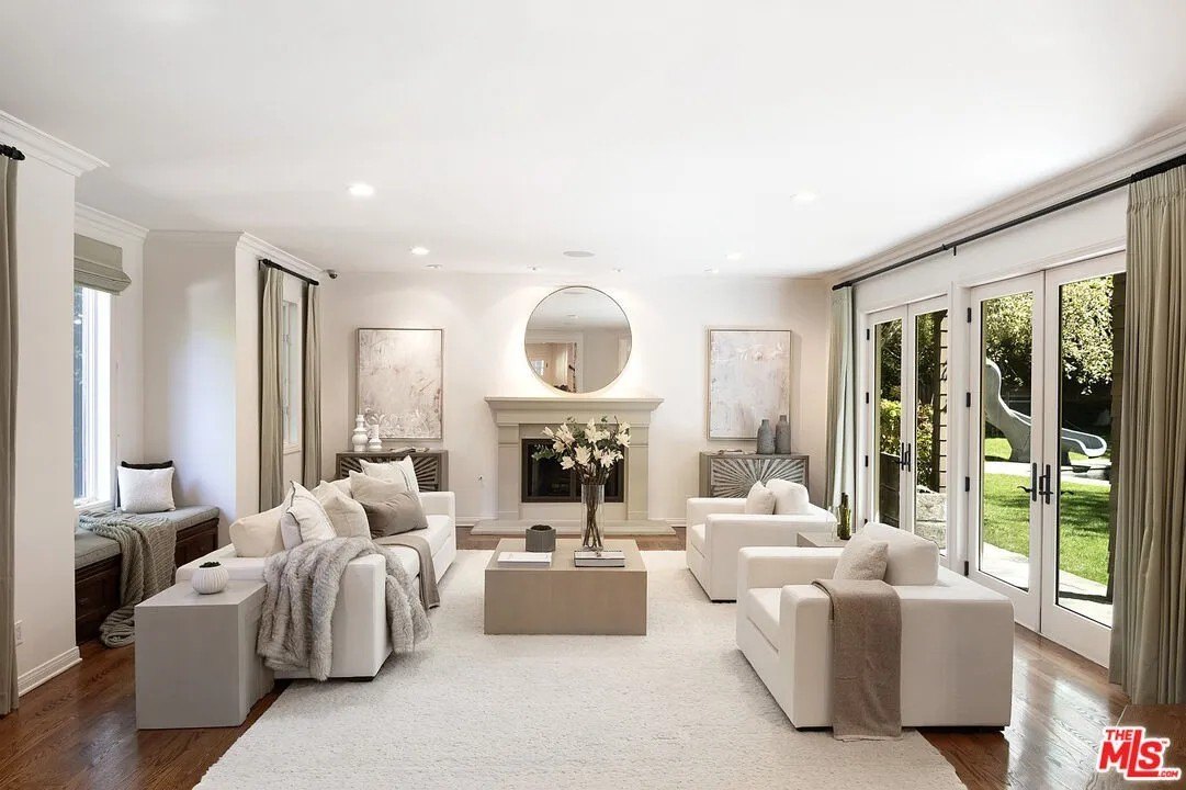 Interiors feature elegant  wood floors, nuetral colored walls, and an abundance of French doors that lead out to the leafy grounds.